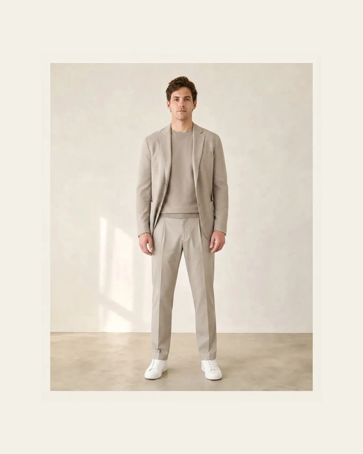 Stone blazer and trousers with a tonal knit and white sneakers