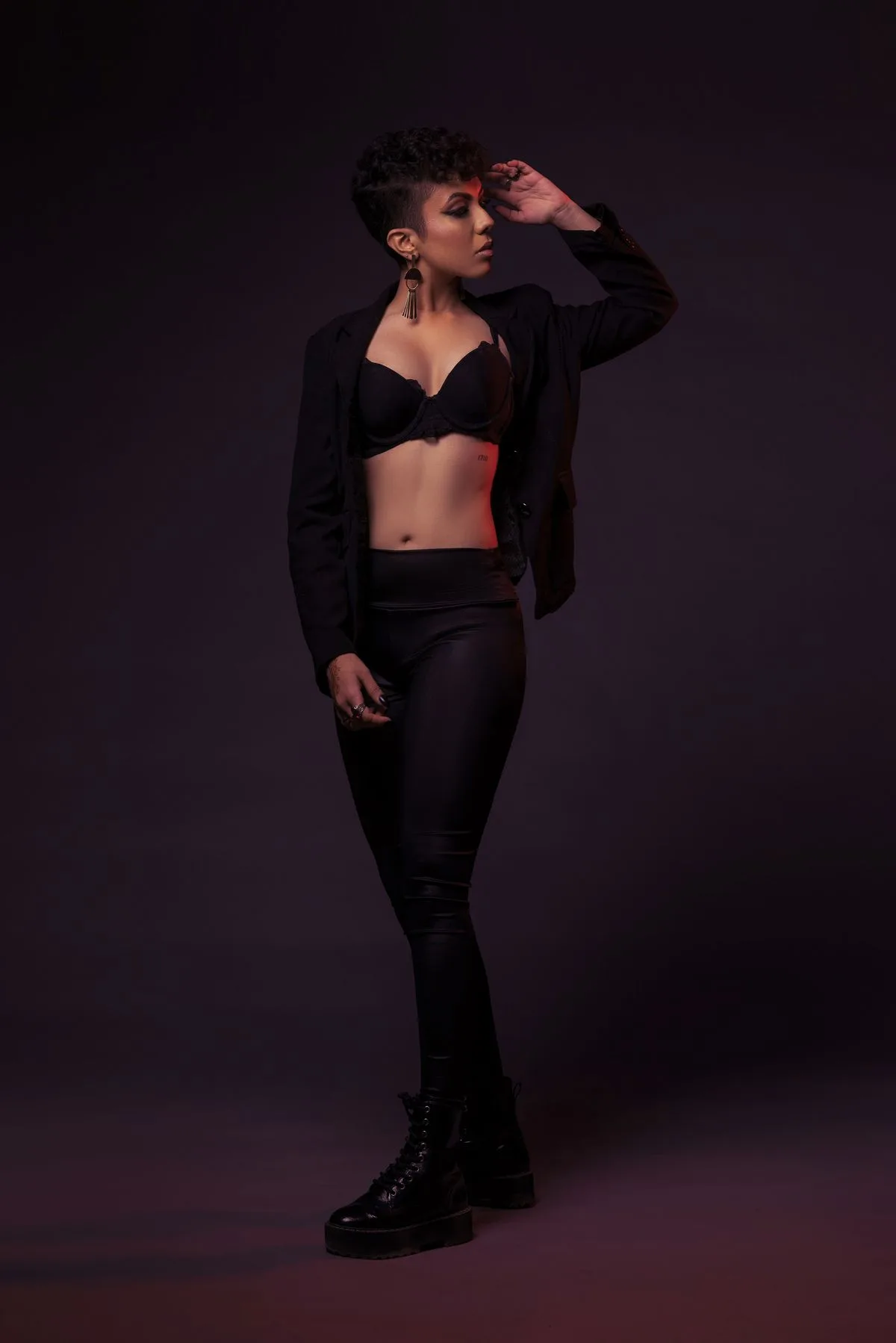 Black blazer and trousers with a bralette in dramatic lighting