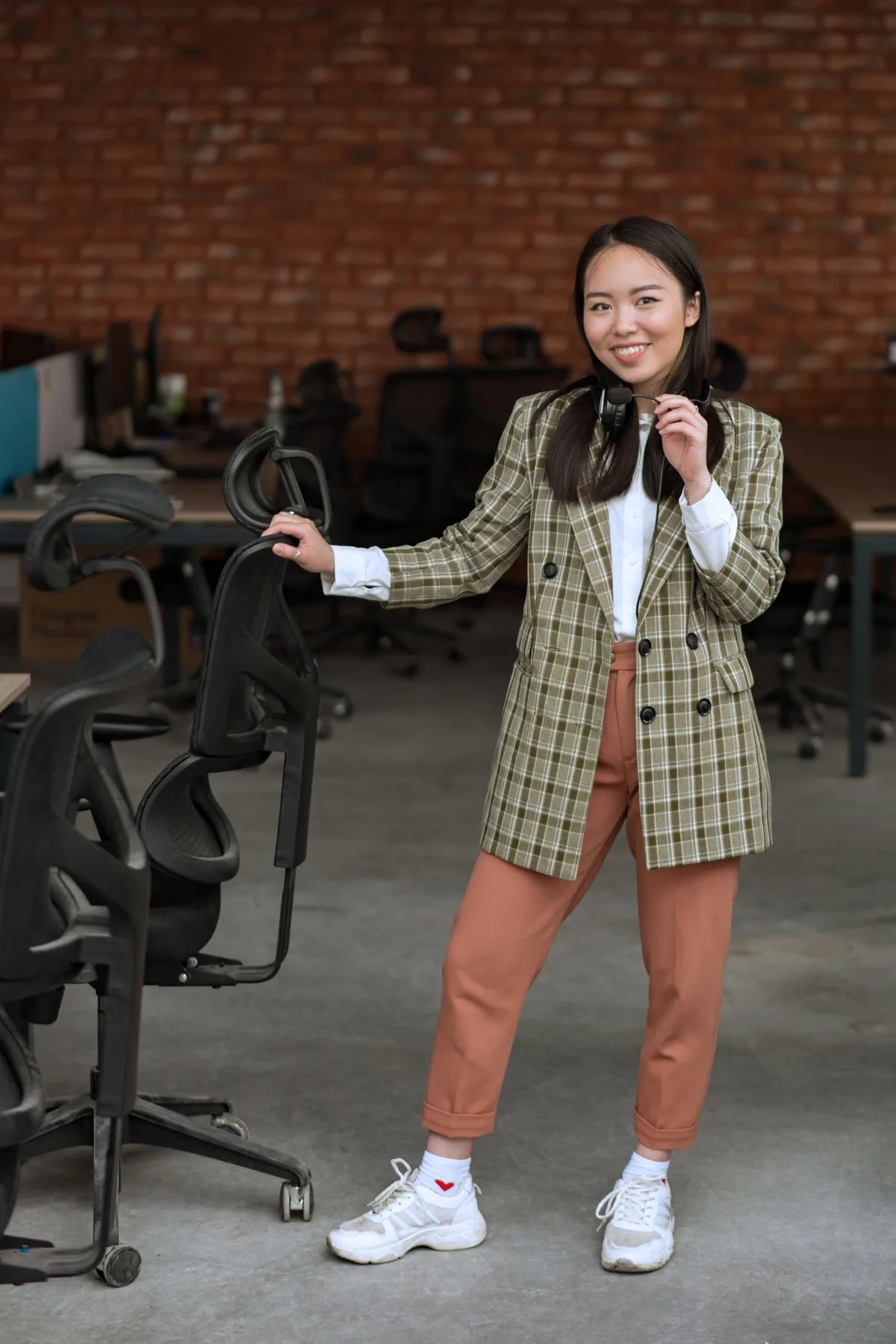 Plaid blazer with white shirt, pleated skirt, and white sneakers