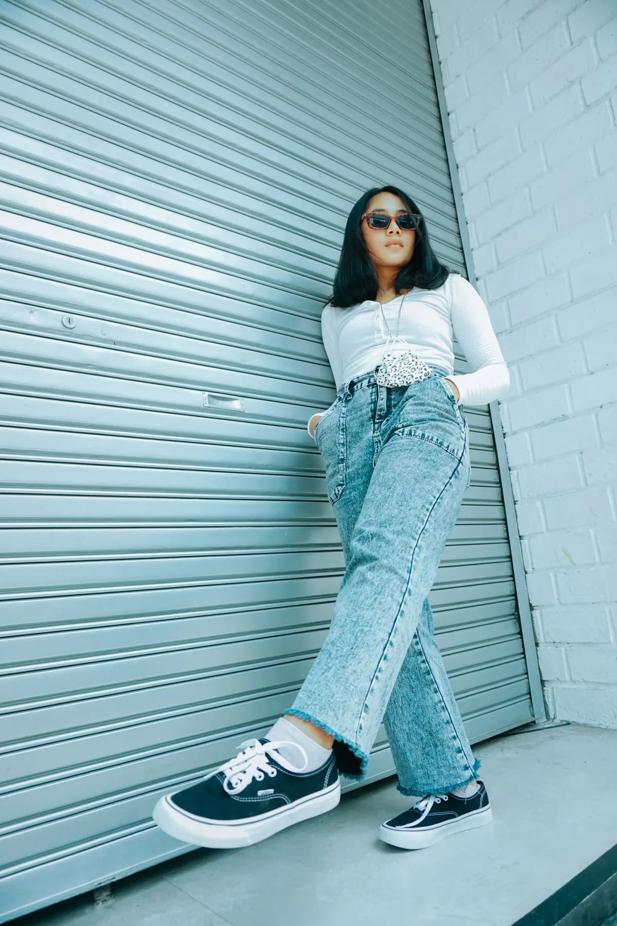 Pale denim corset top with wide jeans and black sneakers