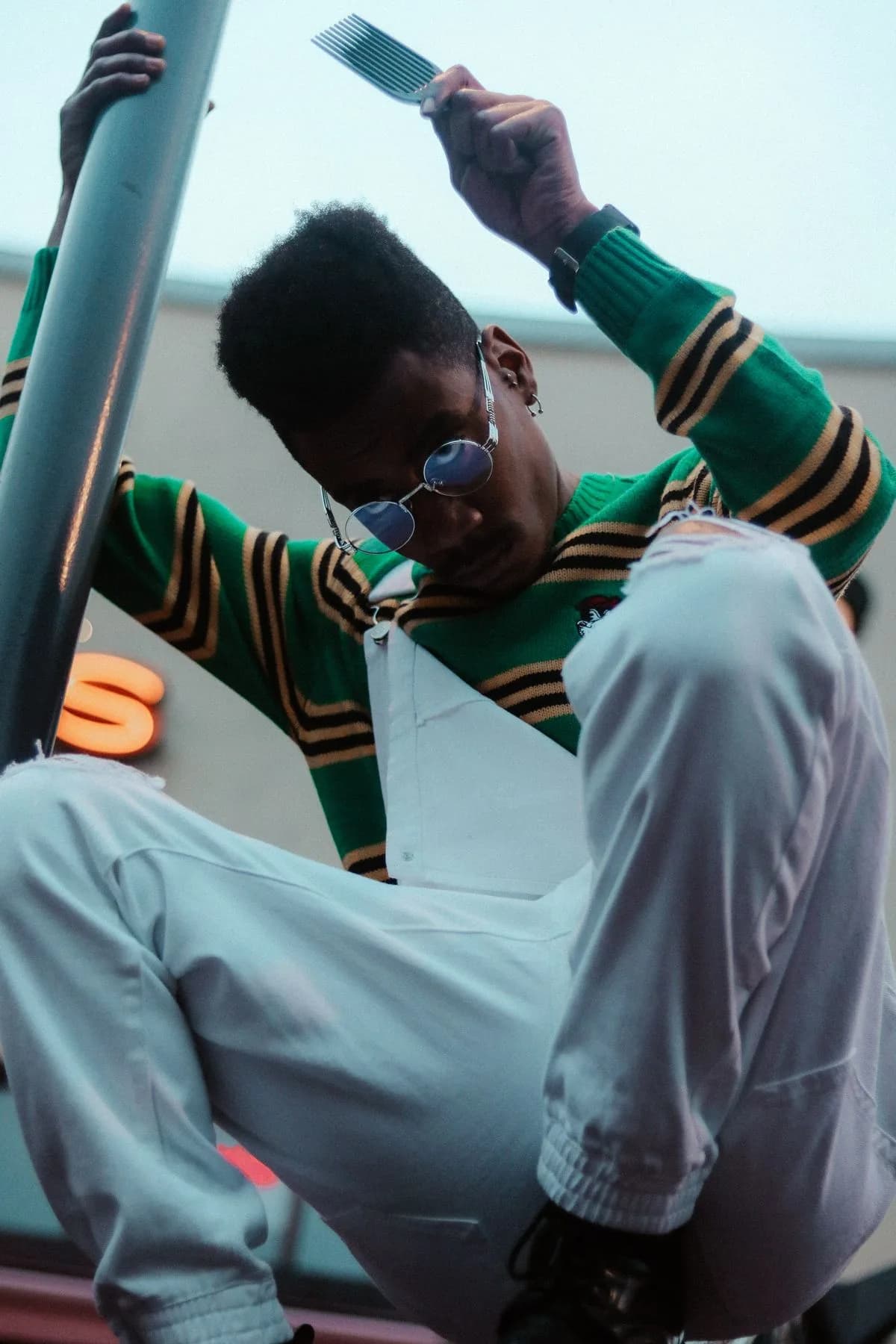 Green striped sweater with pale wide-leg trousers and sunglasses
